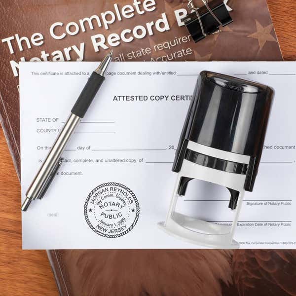 Stamped notary seal beside pen and notary record book