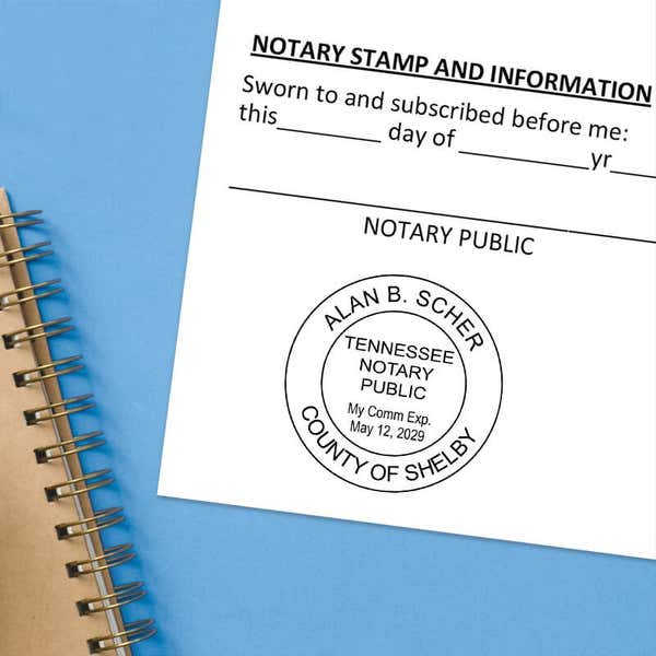 Notary public stamp impression on signed document above notebook