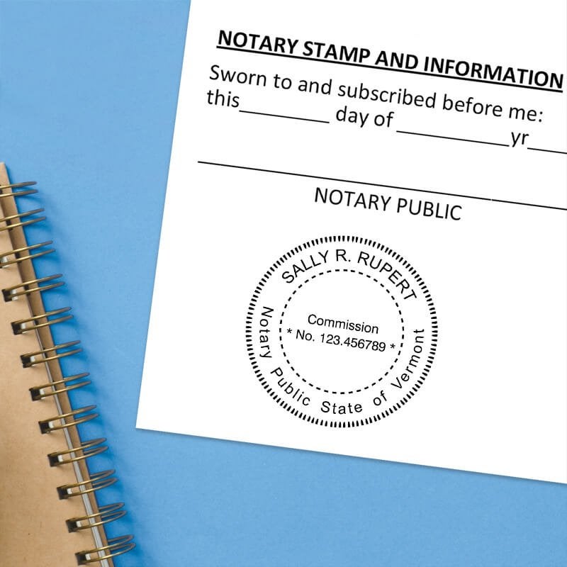 Vermont notary stamp impression on white paper on a blue notebook. 