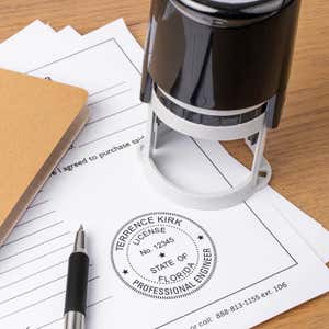 State of Florida Engineer Seal stamp impression on a document next to the stamp and a pen