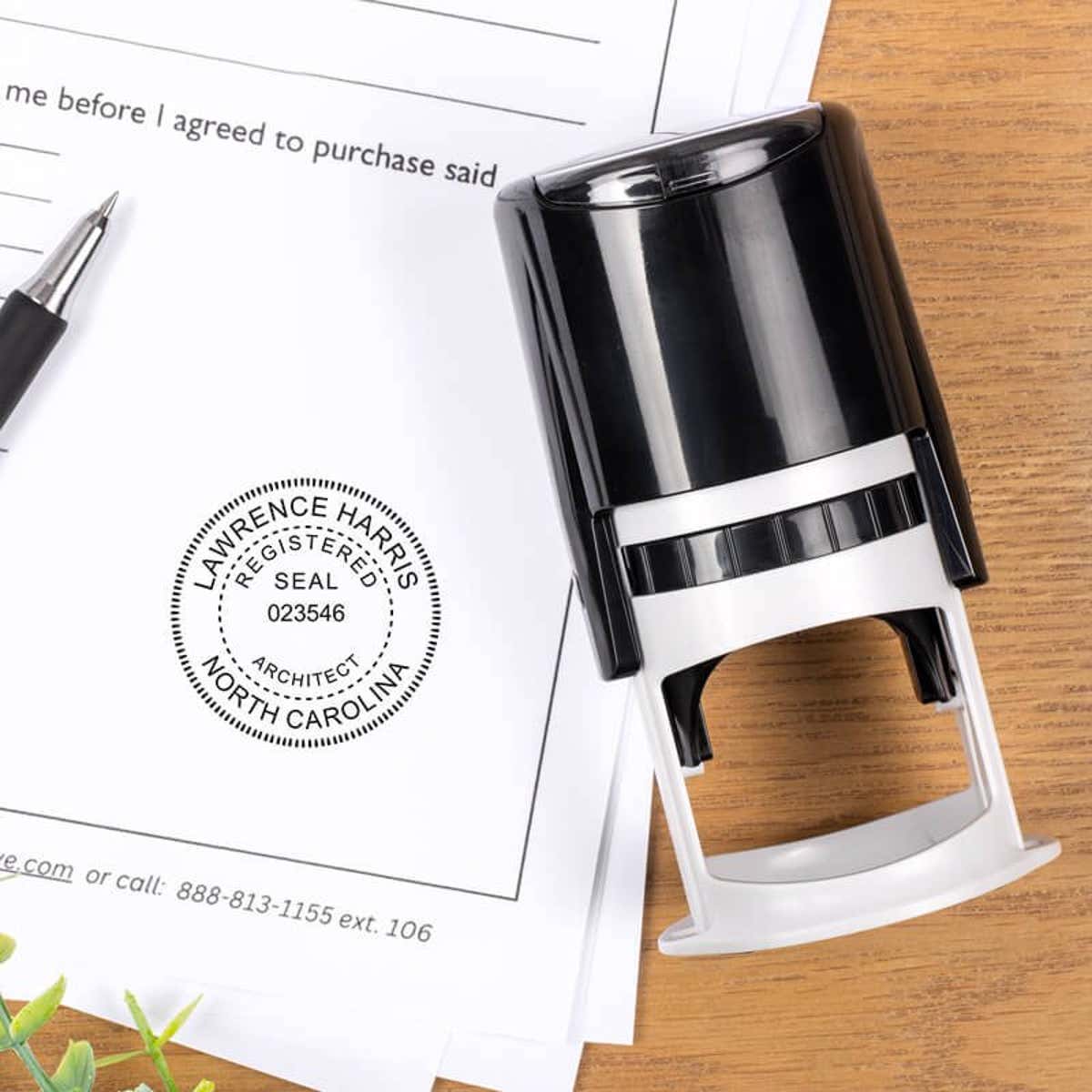 Self-inking architect stamp beside contract with seal impression for official North Carolina documents.    