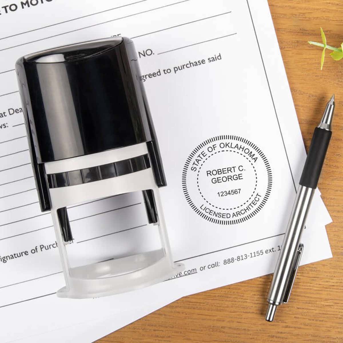 The State of Oklahoma Architect Seal on a document with a self-inking stamp and a pen