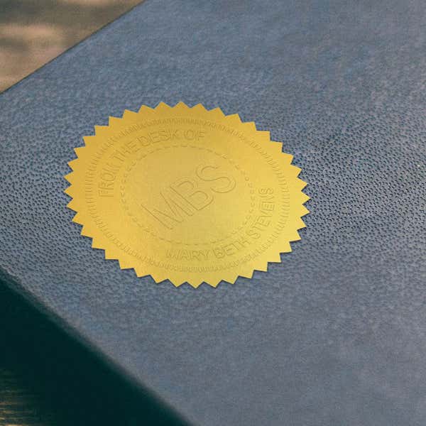 Example of Custom Initial Embosser Impression on Gold seal sticker on blue book