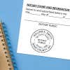    North Carolina notary stamp impression on white paper on a blue notebook. 