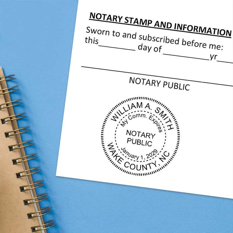    North Carolina notary stamp impression on white paper on a blue notebook. 