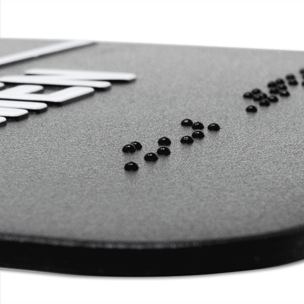 Close up on the braille on the ADA restroom sign