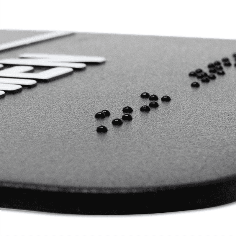 Close up on the braille on the ADA restroom sign