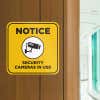 Yellow background custom sign with bold black text reads Notice security cameras in use and has surveillance camera icon