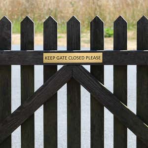 2x12 custom engraved brass sign on a fence