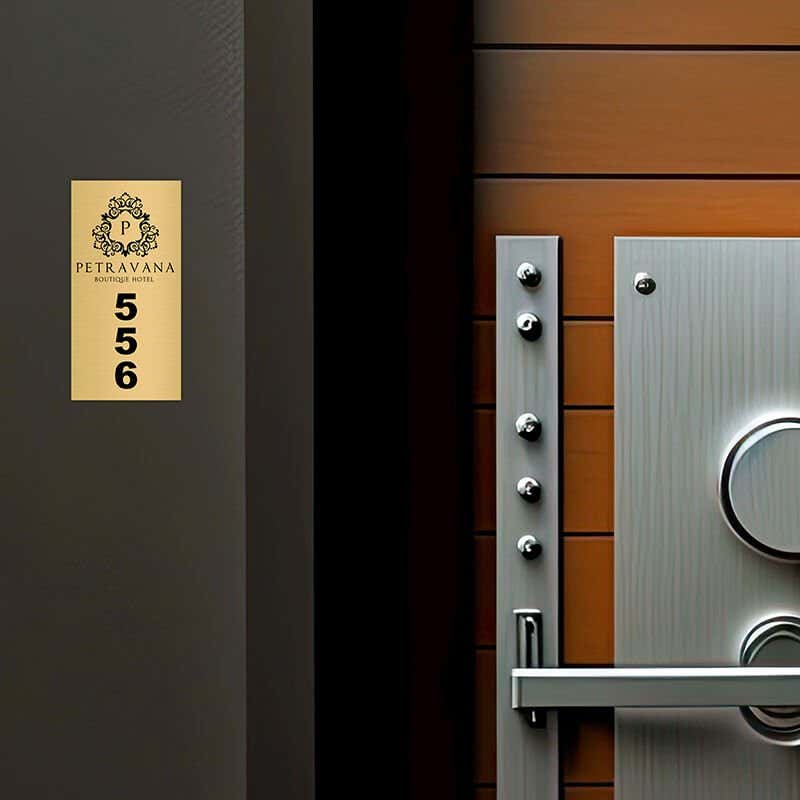 2x1 custom engraved brass sign displayed by a door