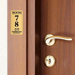 4x2 custom engraved brass sign displayed by a door