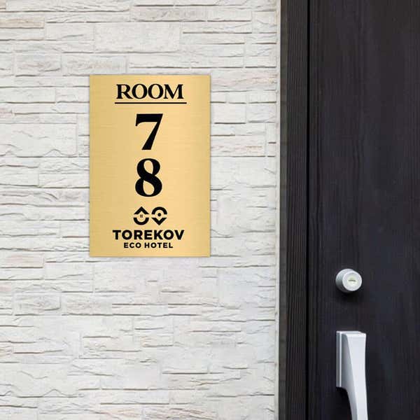 6x4 custom engraved brass sign displayed by a door
