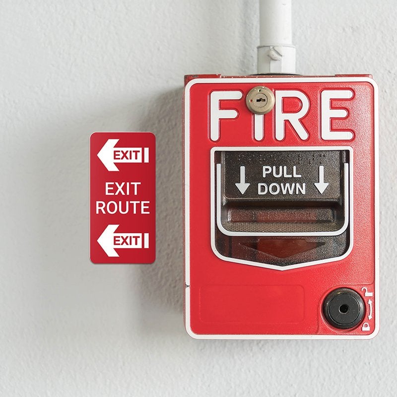 A vertical engraved plastic sign for an exit route