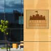 10" x 12" printed brass sign displayed next to an entrance 