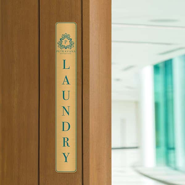 14x2 printed brass sign displayed by a doorway