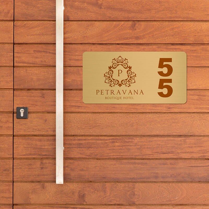 2x4 printed brass sign displayed on a wooden wall