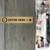 4x20 printed brass sign displayed by an entrance 
