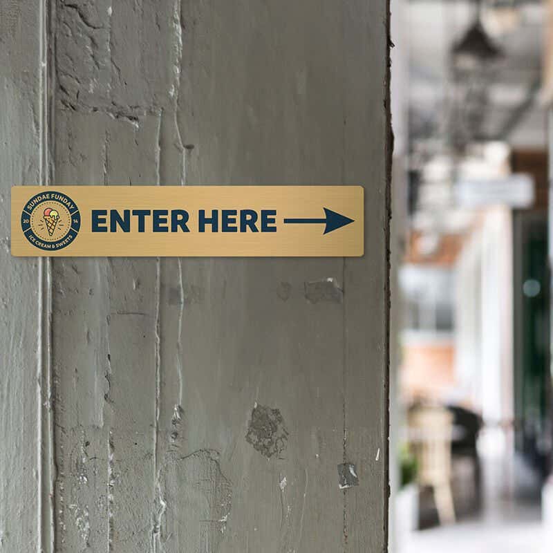 4x20 printed brass sign displayed by an entrance 