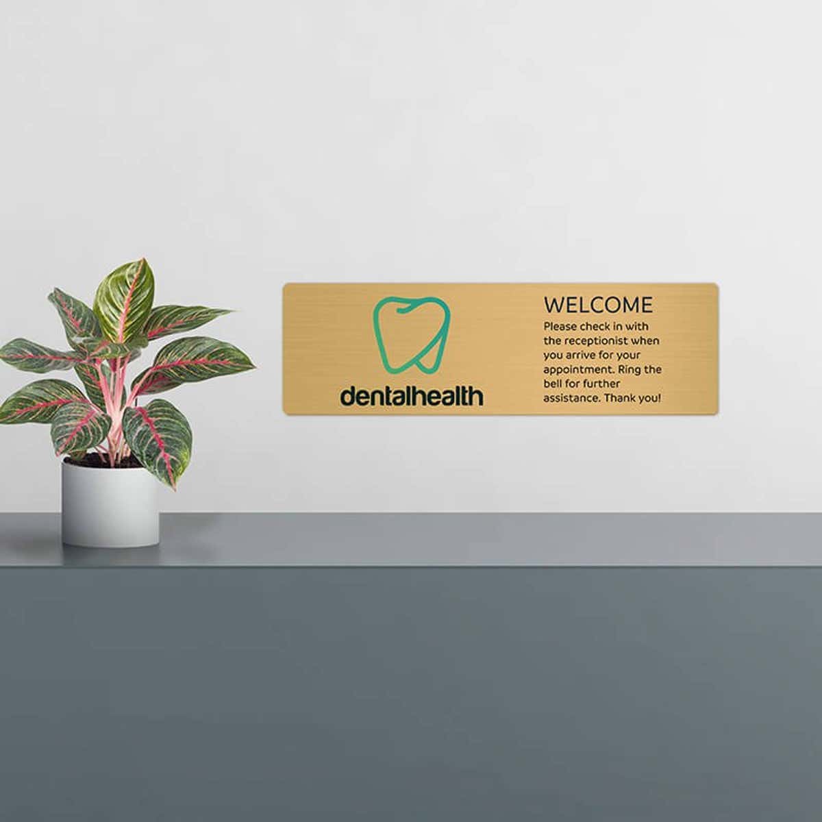 6x20 printed brass sign displayed by a front desk