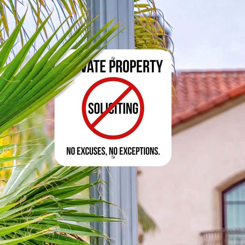 Private property No soliciting sign hung on a metal post reading, "No excuses, no exceptions"