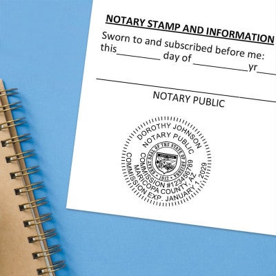 Arizona notary stamp impression on jurat form next to spiral notebook on blue background.