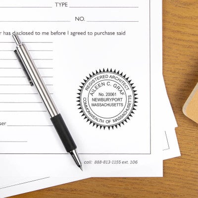 The State of Massachusetts Architect Stamp at the bottom of a document next to a pen