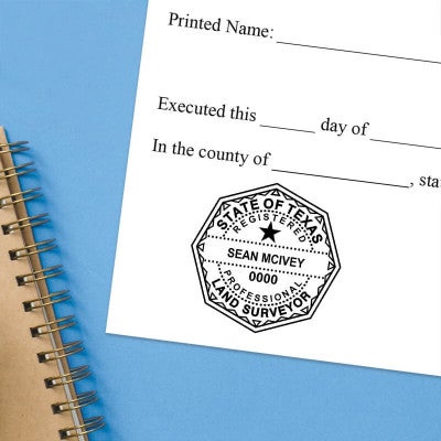 Texas notary stamp impression on white paper on a blue notebook. 