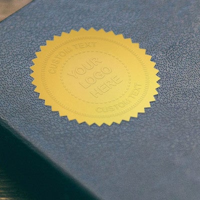 Example of the Custom Text Logo Embosser impression on gold seal on a blue book