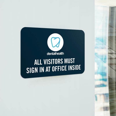 Navy-blue background dental office sign that reads All visitors must sign in at office inside