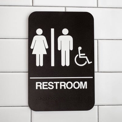 Brown Unisex Handicap Sign Hanging on a Wall