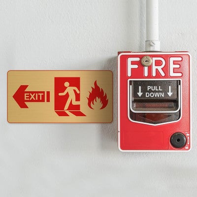 3x6 printed brass sign next to a fire alarm
