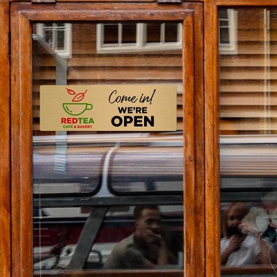 4x12 printed brass sign hanging on a glass door