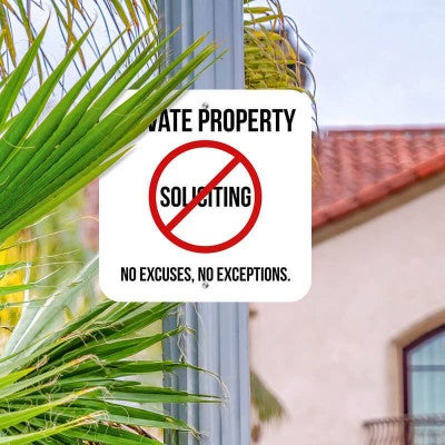 Private property No soliciting sign hung on a metal post reading, "No excuses, no exceptions"