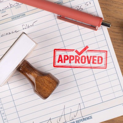 Wooden rubber stamp with approved imprint used for office paperwork approval