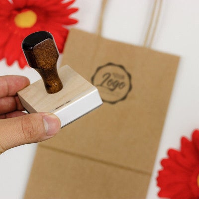 An example of a hand holding a custom logo stamp