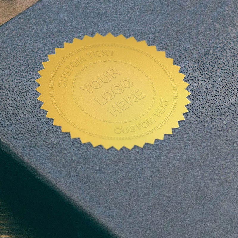 Example of the Custom Text Logo Embosser impression on gold seal on a blue book