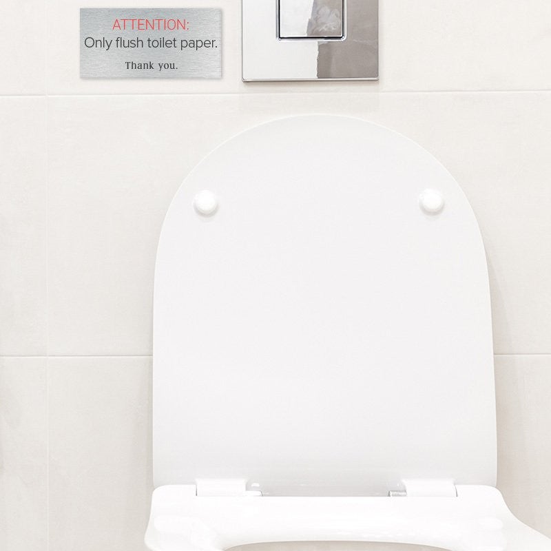 Silver Plastic Sign With Red and White Text Saying ATTENTION Only flush toilet paper