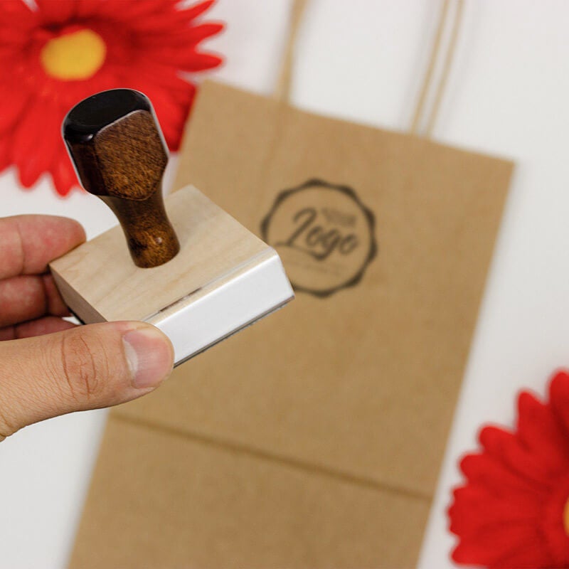 An example of a hand holding a custom logo stamp