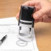 Hand presses Vermont notary stamp onto motor-vehicle disclosure form.