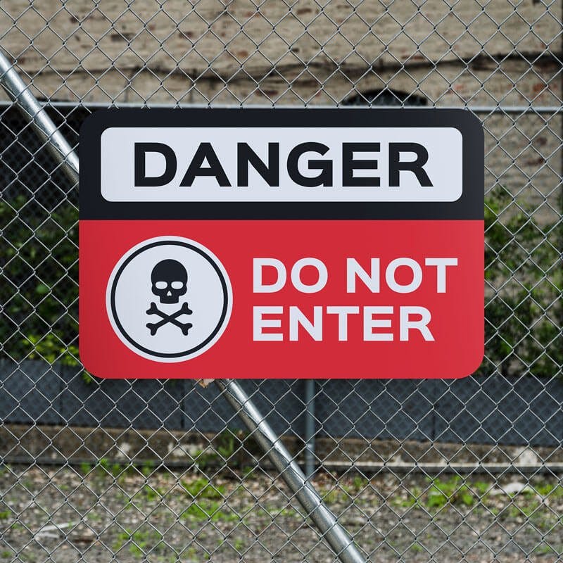 Danger Do Not Enter sign with skull image with red background with bold white and black text.