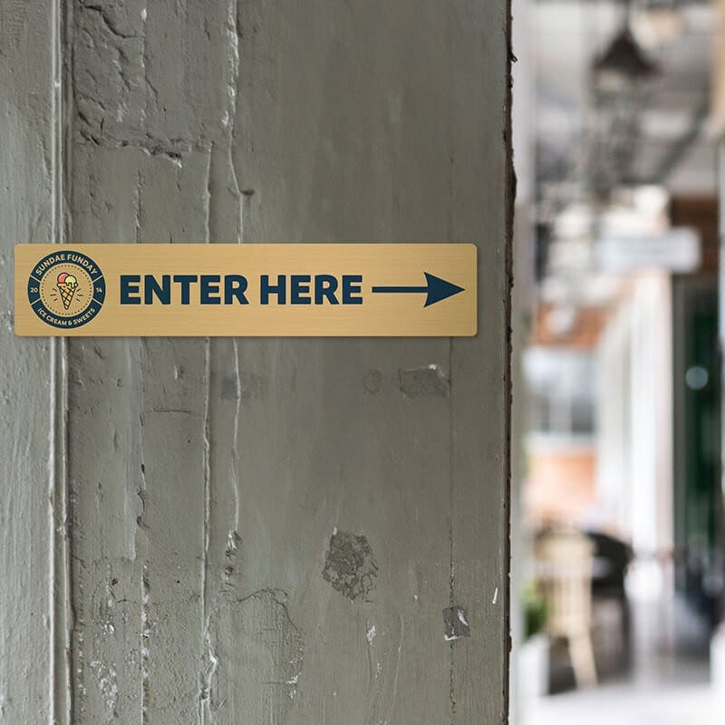 4x20 printed brass sign displayed by an entrance 