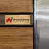 6x16 printed brass sign displayed on a wooden wall