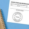 Iowa notary stamp on a white document on a blue notebook.