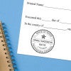 Texas engineer stamp impression on form with blue spiral notebook on light blue background.