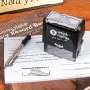 The Wyoming Rectangle Notary Seal self-inking stamp being used on a document