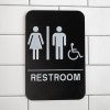 Black Unisex Handicap Sign Hanging on a Wall