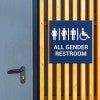 A blue engraved all gender restroom sign 