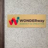 6x18 printed brass sign displayed by a doorway