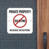 Bold Private property sign with a no soliciting symbol on a white background hung up on a gray wall.
