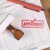 Wooden rubber stamp with approved imprint used for office paperwork approval
